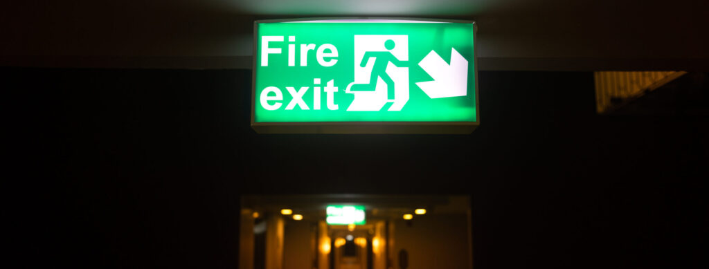 a fire exit sign in a dark hallway.