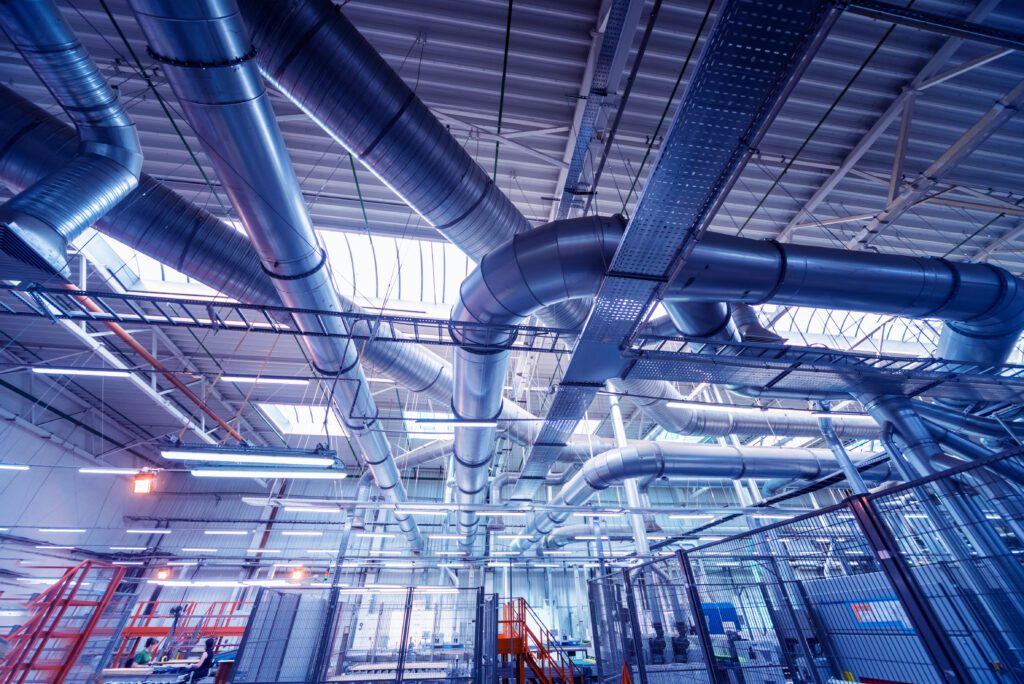 a large industrial building with pipes and ducts.