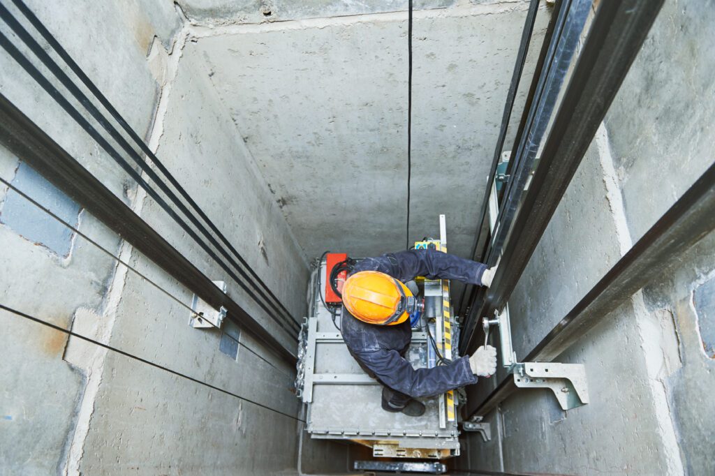 a man in a helmet is working in a lift.