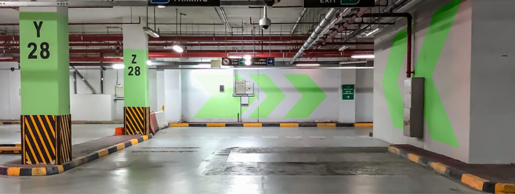 a parking garage with green arrows painted on the walls.