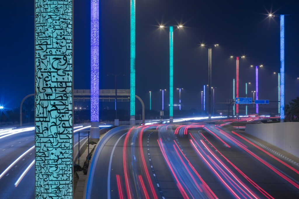 a traffic light pole is lit up at night.